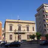 E proprio accanto al tempio religioso, in piazzetta Sant�Antonio, si nasconde il prospetto angolare color ocra di Palazzina Tinelli, stretto sull�altro lato da un alto fabbricato residenziale di otto piani